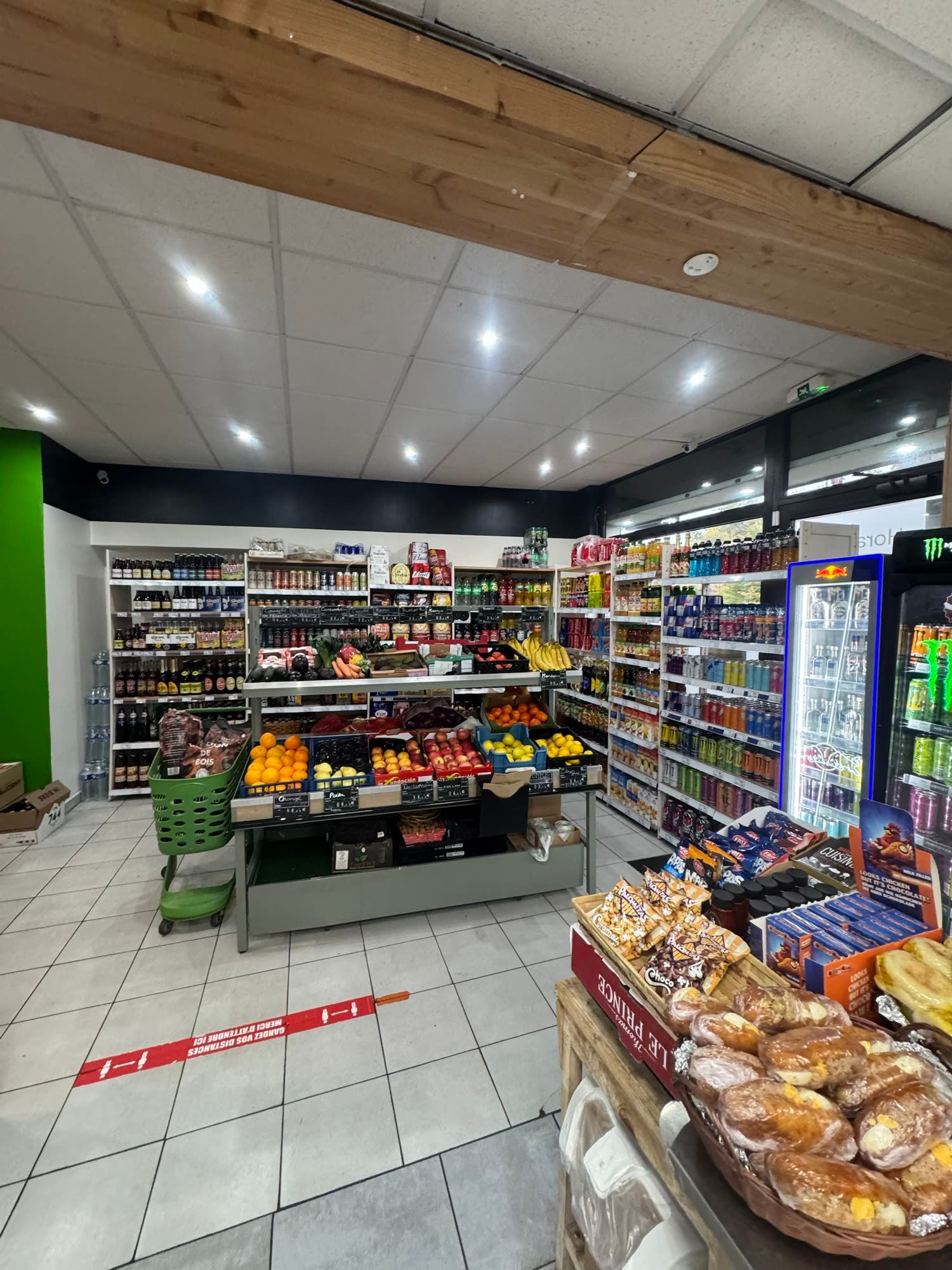 L'étal de fruits et légumes devant les murs de boissons